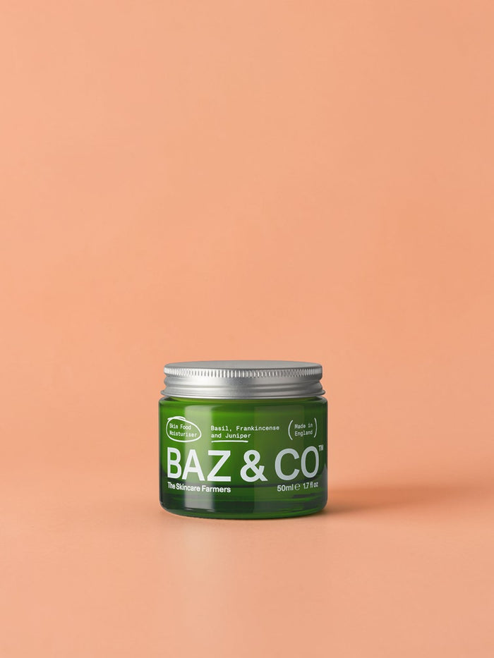 Baz & Co Skincare Skin Food Moisturiser in a green glass jar with a silver lid. Contains basil, frankincense, and juniper.